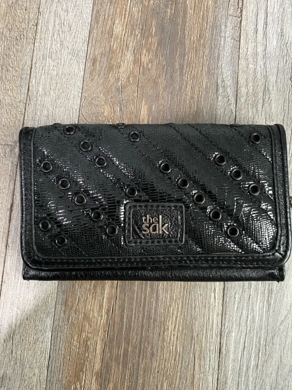 The Sak Black Quilted Eyelet Trifold Leather Wallet with Logo Plaque
